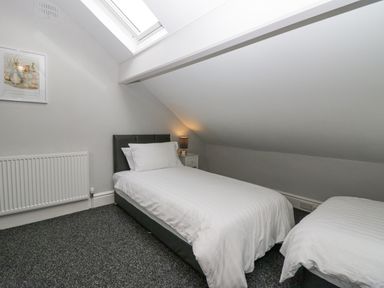 A bedroom with two single beds under a slanted ceiling and a skylight at Park Beck 3 in Windermere