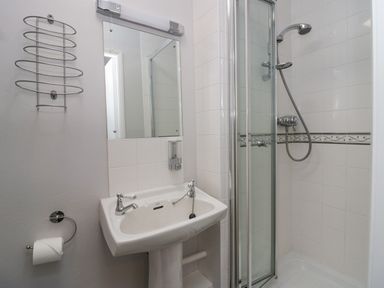 A bathroom with a sink and a shower cubicle with tiles at Park Beck 3 in Windermere