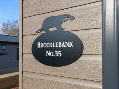 A house sign with a badger figure and the text Brocklebank No 35 on an exterior wall at Brocklebank Lodge 35 High Hesket near Armathwaite