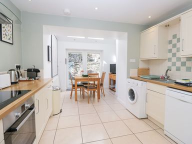 A kitchen with a table and chairs and appliances at Rothay Cottage in Ambleside