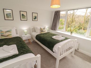 A bedroom with two beds and a window at Rothay Cottage in Ambleside