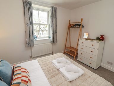 A bedroom with a bed and dressers at Rothay Cottage in Ambleside
