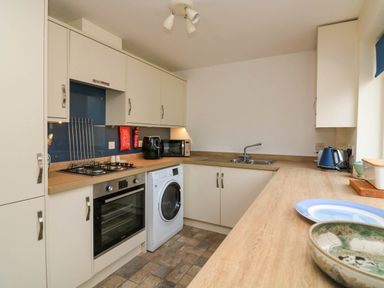 A kitchen with oven washing machine sink kettle and countertop at 8 Dartmouth House Dartmouth