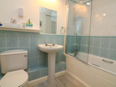 A bathroom with a toilet sink and bathtub with shower at 8 Dartmouth House in Dartmouth