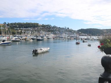 A harbor with boats on water and houses on a hillside at 8 Dartmouth House in Dartmouth