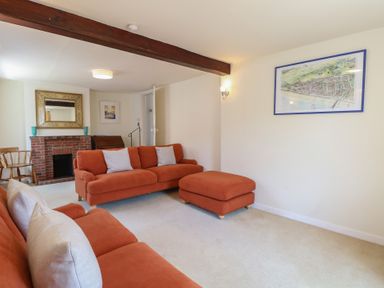 A living room with a sofa and fireplace at Iona Cottage Southwold
