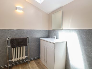 A bathroom with a sink and towel radiator at Iona Cottage Southwold