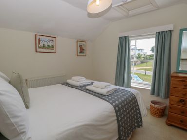 A bedroom with a bed and framed art at Iona Cottage Southwold