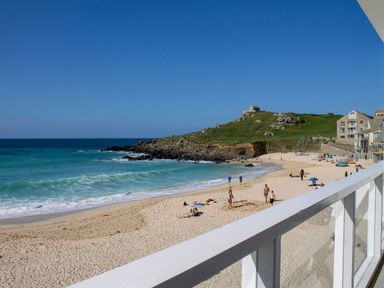 A beach with people on the sand near the ocean and buildings at Louies Loft in St Ives