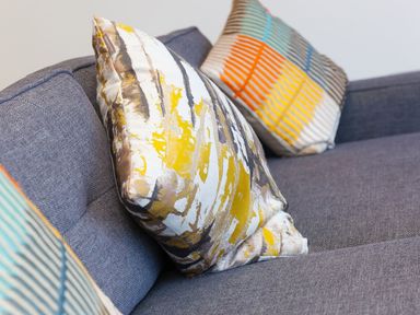 Decorative pillows on a grey fabric sofa at Louies Loft in St Ives