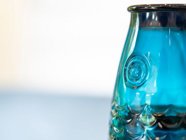A close-up of a blue glass object with circular and scale patterns on a light surface at Maple Lodge in Angarrack