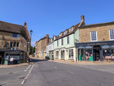A street with shops and old stone buildings under a clear sky at 30 Fleet Street in Beaminster