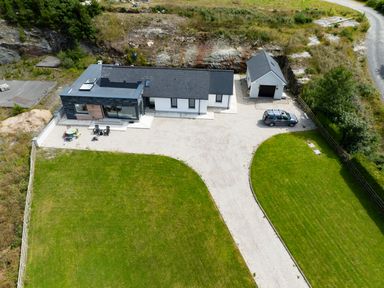 An aerial view of a house with a driveway a garage a car and a lawn at Ballyness Bay in Killult Upper near Gortahork County Donegal