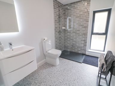 A bathroom with a sink cabinet toilet walk in shower and window at Ballyness Bay in Killult Upper near Gortahork County Donegal