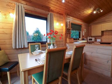A dining room with a table and chairs at Elderberrys Lodge in Bideford