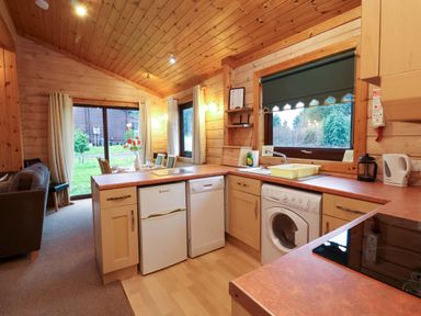 A kitchen with appliances and a window at Elderberrys Lodge in Bideford