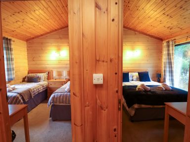 A bedroom with two beds and a window at Elderberrys Lodge in Bideford