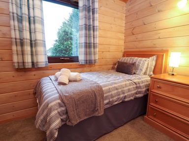 A bedroom with a bed and lamp at Elderberrys Lodge in Bideford