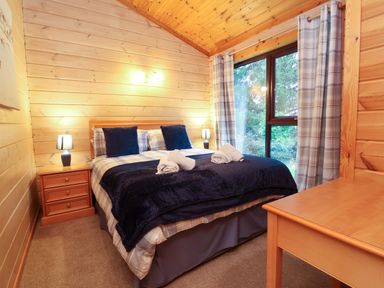 A bedroom with a bed and window at Elderberrys Lodge in Bideford