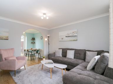 A living room with a grey sofa, armchair, and dining area at 20 Honeycroft Bourton-On-The-Water