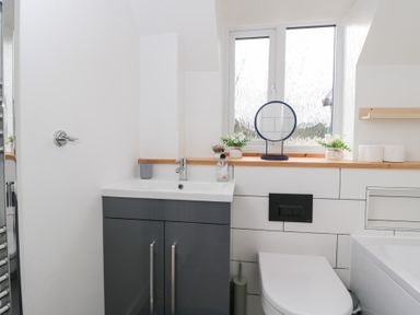 A bathroom with sink, toilet and mirror at 20 Honeycroft, Bourton-On-The-Water