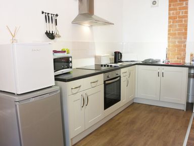 A kitchen with a fridge freezer microwave oven stovetop kettle and sink at Woodside Cottage in Kerry