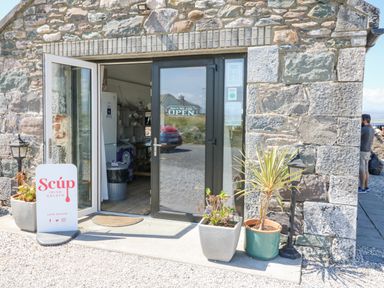Entrance to a stone building with glass doors and potted plants outside at Knockbrack in Lonart near Killorglin County Kerry