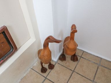Two wooden duck figurines on a tiled floor in a corner near a door at Knockbrack Lonart near Killorglin County Kerry