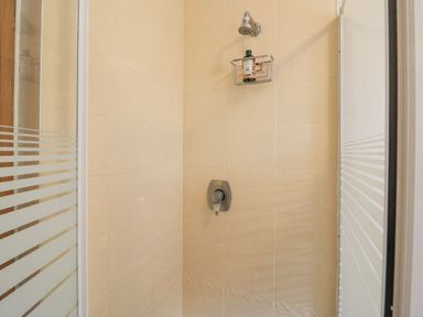 A shower stall with a showerhead and soap holder inside at Knockbrack in Lonart near Killorglin County Kerry