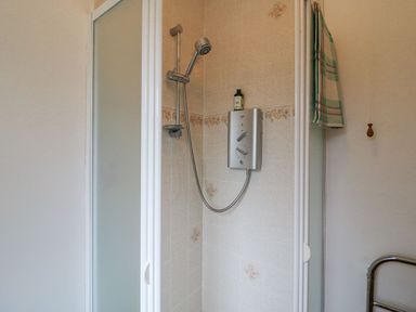 A shower enclosure with a handheld showerhead and a control panel inside a bathroom at Knockbrack Lonart near Killorglin County Kerry