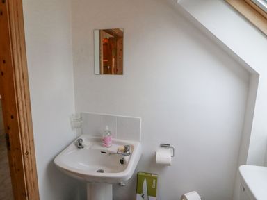 A bathroom sink with soap dispenser and mirror above next to a toilet roll holder at Knockbrack in Lonart near Killorglin County Kerry