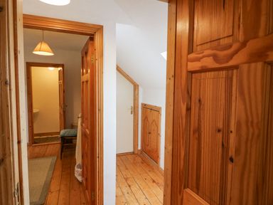 A wooden hallway with doors leading to a bathroom and a small room at Knockbrack in Lonart near Killorglin County Kerry
