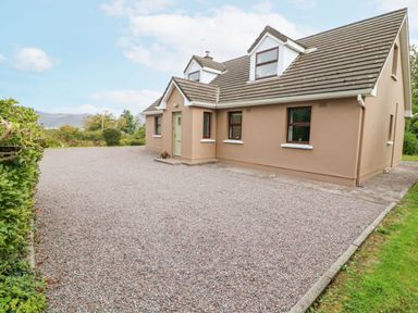 A detached house with a gravel driveway and a hedge on the left side at Knockbrack in Lonart near Killorglin County Kerry