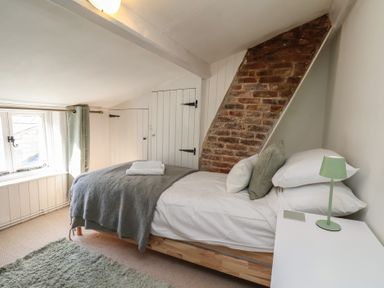 A bedroom with a single bed next to a window and a bedside table with a lamp at Field View in Ruswarp
