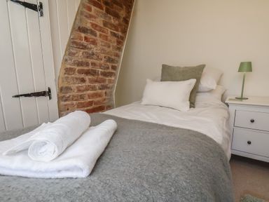 A bedroom with a bed with pillows and folded towels at Field View in Ruswarp