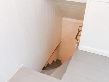 A narrow staircase leading down with white walls and grey steps at Field View in Ruswarp