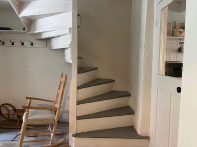 A staircase and rocking chair in an entrance hall at Field View in Ruswarp