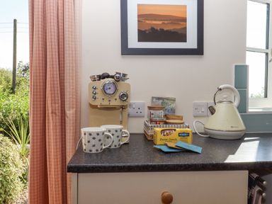 A kitchen counter with a coffee machine two mugs a kettle and a box of biscuits at The Wheelhouse Beacon near Yarcombe