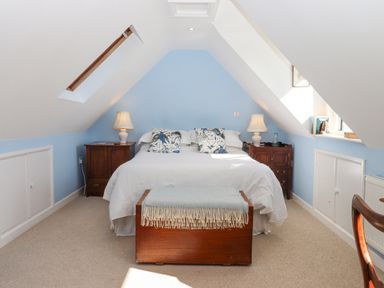 A bedroom with a bed centered between two bedside tables each with lamps at The Wheelhouse Beacon near Yarcombe