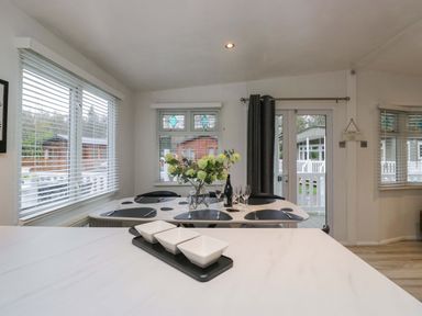 A dining room with a table and chairs at Cosy Corner White Cross Bay near Troutbeck Bridge
