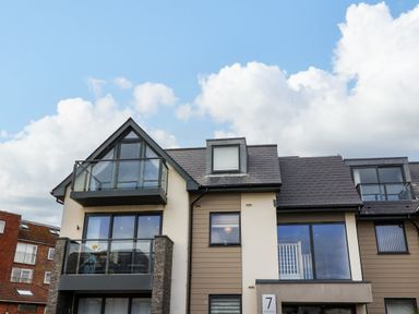 A modern apartment building with balconies and large windows under a blue sky at 7 Warren Edge Close in Bournemouth