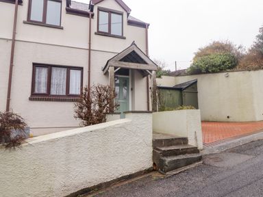 Exterior of a two-story house with a green front door and steps leading to the entrance at Cheriton in Pembroke Dock