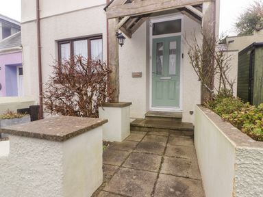 A front entrance with concrete paving plants and a green door at Cheriton in Pembroke Dock