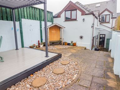 A paved outdoor area with stepping stones gravel pots and a wooden bench at Cheriton in Pembroke Dock