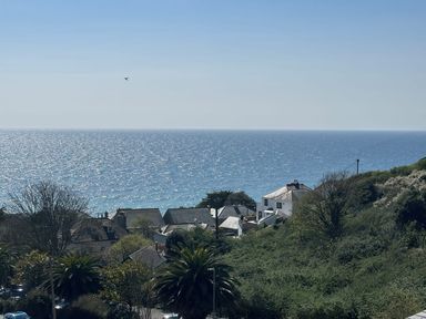 A coastal view with houses trees and the ocean at Waves Edge in Looe
