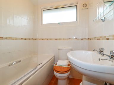 A bathroom with a bathtub toilet and sink at Newtrain Bay near St Merryn