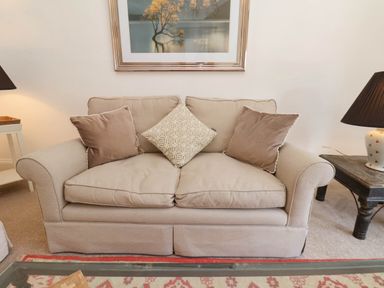 Beige sofa with three cushions and two side tables with lamps in a living room at Flat 1 in Scarborough