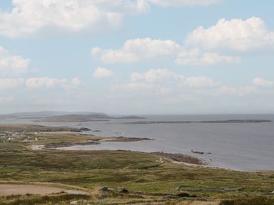 A coastal landscape with scattered houses on grassy land by the sea at Nelly's House in Gortahork County Donegal