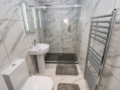 A bathroom with a toilet sink shower and towel rack at Little Pale Near Whitland