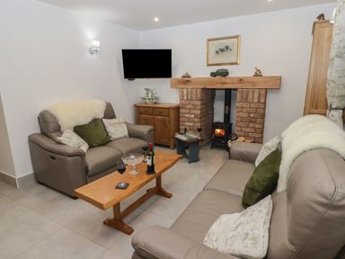 A living room with two leather sofas a wooden coffee table and a brick fireplace at Little Pale Near Whitland
